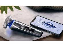 Charger l&#39;image dans la galerie, Rasoir Philips avec un téléphone affichant une application connectée. Le rasoir est sur une surface en marbre.
