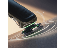 Charger l&#39;image dans la galerie, Gros plan sur un rasoir électrique noir avec bord éclairé vert, rasant une surface.
