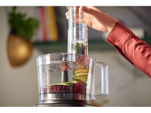 Charger l&#39;image dans la galerie, Une personne ajoutant des ingrédients dans un robot culinaire. Le robot est en grande partie transparent.
