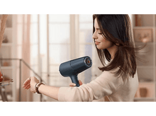 Charger l&#39;image dans la galerie, Femme utilisant un sèche-cheveux bleu.
