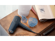 Charger l&#39;image dans la galerie, Sèche-cheveux, diffuseur et embout coiffant sur une surface en bois avec un magazine.
