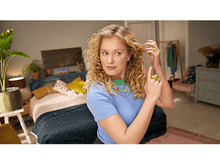 Charger l&#39;image dans la galerie, Une femme en haut bleu dans une chambre, se touchant les cheveux.
