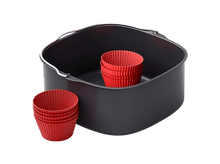 Charger l'image dans la galerie, Un panier de friteuse à air avec des moules à cupcakes rouges à l'intérieur et à côté, sur fond noir.
