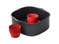 Un panier de friteuse à air avec des moules à cupcakes rouges à l'intérieur et à côté, sur fond noir.