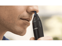 Charger l&#39;image dans la galerie, Un homme utilise un coupe-nez Philips noir. Le produit est étiqueté &#39;lavable&#39;.
