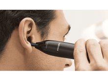 Charger l&#39;image dans la galerie, Un homme utilise un coupe-poils de nez Philips noir près de son oreille, plan rapproché.

