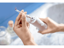 Charger l&#39;image dans la galerie, Une personne tenant un appareil blanc, probablement un hydropulseur, avec une embout.
