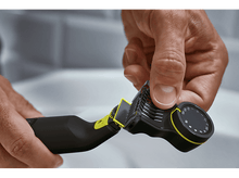 Charger l&#39;image dans la galerie, Une main ajuste la tête de coupe d&#39;un rasoir noir et jaune.
