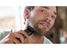 Charger l&#39;image dans la galerie, Un homme se rase la barbe avec une tondeuse, gros plan.
