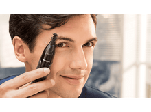 Charger l&#39;image dans la galerie, Un homme utilisant un coupe-poils de nez et d&#39;oreilles Philips noir sur son sourcil.
