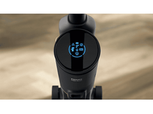 Charger l'image dans la galerie, Vue de dessus d'un aspirateur noir. Le dessus a un écran circulaire affichant des icônes.
