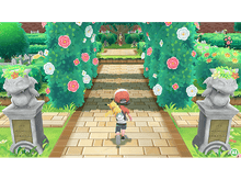 Charger l'image dans la galerie, Une personne avec un chapeau rouge et une chemise bleue marche vers un chemin bordé de fleurs.
