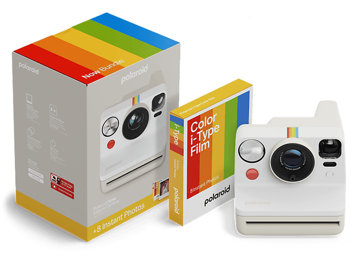 Un appareil photo Polaroid avec une boîte et des films. L'appareil est blanc avec une bande arc-en-ciel.