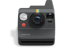 Charger l&#39;image dans la galerie, Appareil photo Polaroid Now, corps gris, bande arc-en-ciel, objectif, bouton rouge, fond noir.
