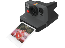 Charger l&#39;image dans la galerie, Un appareil photo Polaroid avec une photo, montrant une personne tenant un chien dans une voiture rouge.
