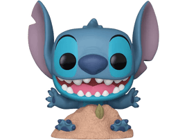 Figurine Stitch, extraterrestre bleu avec de grandes oreilles et dents, sur base sable.