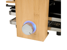 Charger l&#39;image dans la galerie, Une machine à raclette en bois avec un bouton et une lumière bleue.
