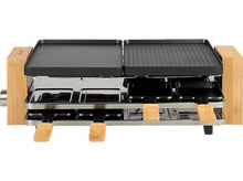 Charger l&#39;image dans la galerie, Gril à raclette sur fond blanc. Dispose d&#39;une base en bois et de surfaces de cuisson noires.
