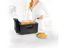 Charger l&#39;image dans la galerie, Femme avec une friteuse, frites dans un panier et une assiette de frites. Fond blanc.
