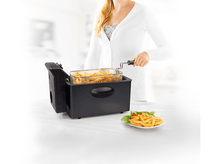 Charger l&#39;image dans la galerie, Femme faisant frire des frites, une assiette de frites et une friteuse sur un fond clair.
