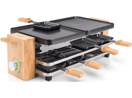Gril à raclette. Surfaces de cuisson noires, poignées et garnitures en bois, base en bambou, détails argentés. Cadran vert.