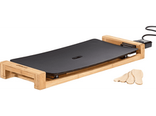 Charger l&#39;image dans la galerie, Une plaque de cuisson noire sur un cadre en bambou avec des spatules en bois. La marque Princess est visible.
