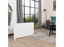 Charger l&#39;image dans la galerie, Un radiateur électrique blanc dans un salon. Il y a une fenêtre, un canapé et une table.
