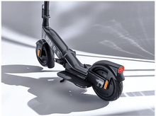 Charger l&#39;image dans la galerie, Une trottinette électrique grise avec un guidon noir et un feu arrière, sur fond blanc.
