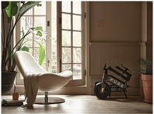 Charger l&#39;image dans la galerie, Une pièce avec un scooter, une chaise et des plantes. Le scooter porte la mention &#39;PURE&#39;.
