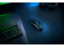 Charger l&#39;image dans la galerie, Souris de jeu noire sur un tapis de souris bleu avec un clavier. Lumières vertes visibles.
