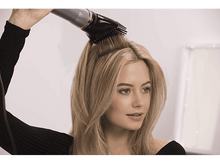 Charger l'image dans la galerie, Une femme sèche ses cheveux blonds avec un sèche-cheveux noir.
