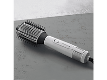 Charger l&#39;image dans la galerie, Brosse coiffante Remington blanche et grise sur surface grise. La brosse a des poils noirs et un corps blanc.
