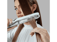 Charger l&#39;image dans la galerie, Femme utilisant un lisseur, lissant les cheveux bruns.
