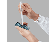 Charger l&#39;image dans la galerie, Mains tenant une pipette au-dessus d&#39;un récipient bleu ouvert. Fond gris clair.
