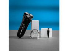 Charger l&#39;image dans la galerie, Rasoir noir Remington R4 avec accessoires sur surface grise, fond bleu.
