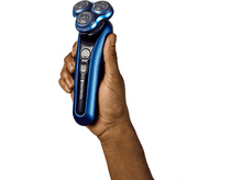 Charger l&#39;image dans la galerie, Main tenant un rasoir électrique bleu et noir sur fond blanc.
