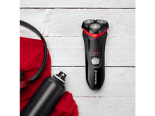 Charger l&#39;image dans la galerie, Un rasoir électrique noir et rouge, à côté d&#39;une bouteille, d&#39;un casque et d&#39;une serviette rouge.
