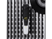 Charger l&#39;image dans la galerie, Tondeuse à barbe Remington blanche et noire sur surface métallique.
