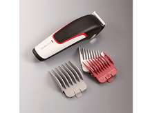 Charger l&#39;image dans la galerie, Tondeuse à cheveux Remington et trois peignes de fixation sur une surface grise.
