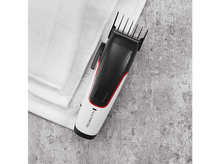 Charger l&#39;image dans la galerie, Tondeuse à cheveux noire et blanche avec des accents rouges sur une serviette blanche sur pierre.
