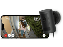 Charger l&#39;image dans la galerie, Un téléphone affiche une vidéo d&#39;un homme, d&#39;une fille et d&#39;un chien en train de marcher. Une caméra Ring noire est fixée sur un mur.
