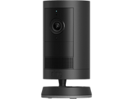 Une caméra de sécurité Ring noire est posée sur une base noire sur fond noir.