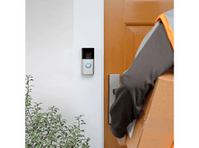 Charger l&#39;image dans la galerie, Une personne livre un colis à une porte avec une sonnette Ring. Des plantes vertes sont à gauche.
