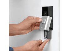 Charger l&#39;image dans la galerie, Les mains d&#39;une personne installant une sonnette Ring argentée. Le fond est un mur blanc et un cadre de porte.
