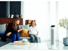 Charger l&#39;image dans la galerie, Une femme et un garçon sont assis sur un canapé, devant un ventilateur dans un salon.
