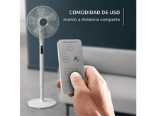 Charger l&#39;image dans la galerie, Une main tient une télécommande pour un ventilateur blanc. Le ventilateur est en arrière-plan. Texte : &#39;COMODIDAD DE USO mando a distancia compacto&#39;.
