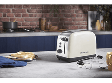 Charger l&#39;image dans la galerie, Un grille-pain crème avec du pain et un couteau sur un comptoir devant un mur de briques.
