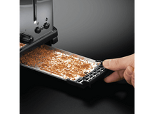 Charger l&#39;image dans la galerie, Grille-pain avec le tiroir sorti, plein de miettes. Une main tient le tiroir. Fond noir.
