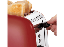Charger l&#39;image dans la galerie, Grille-pain rouge avec tranches de pain. Une main ajuste le cadran de brunissage.
