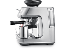 Charger l&#39;image dans la galerie, Machine à expresso argentée avec moulin noir, pichet à lait argenté et réservoir d&#39;eau.
